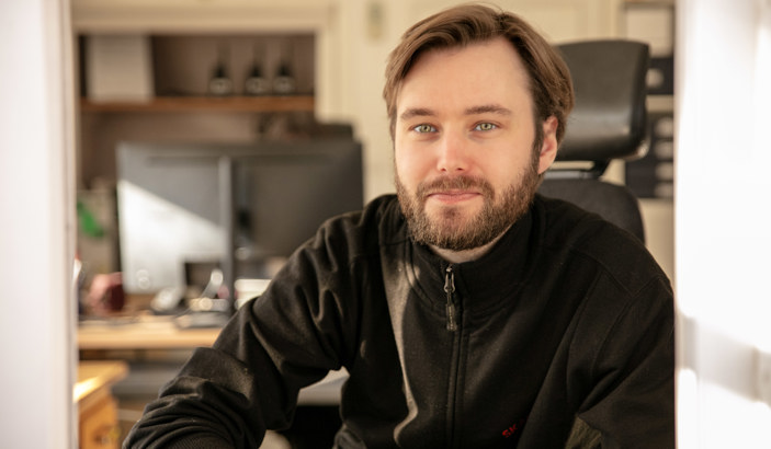 En Seko-medlem som jobbar på Skansen tittar ut från en biljettlucka och in i kameran.